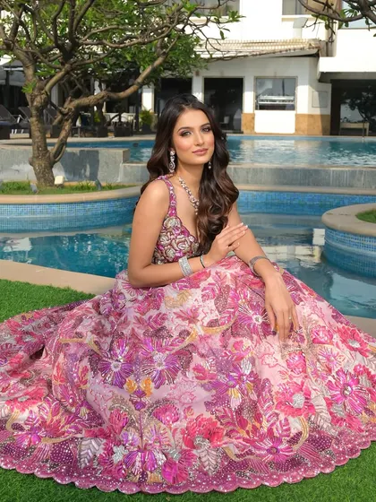 A princess moment. The full, flowing floral skirt of her lehenga creates a beautiful silhouette, complemented by soft makeup and elegant hair that feels truly magical.