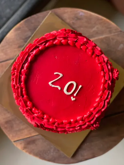 A top-down view of the bold red 20th birthday cake.