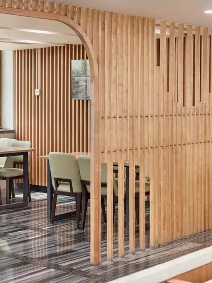 A detail shot from Fortis Ludhiana, showing how we use wooden slats to create visual interest and define smaller, more intimate seating areas within a larger space. This balances openness with a sense of privacy.