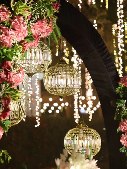 A close-up of the hanging crystal lanterns and pink florals that created a romantic and glamorous photo booth at a sangeet.