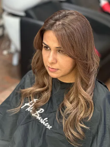 A classic brunette transformation. We added soft, warm highlights and styled the hair with gentle waves for a timeless and elegant look.