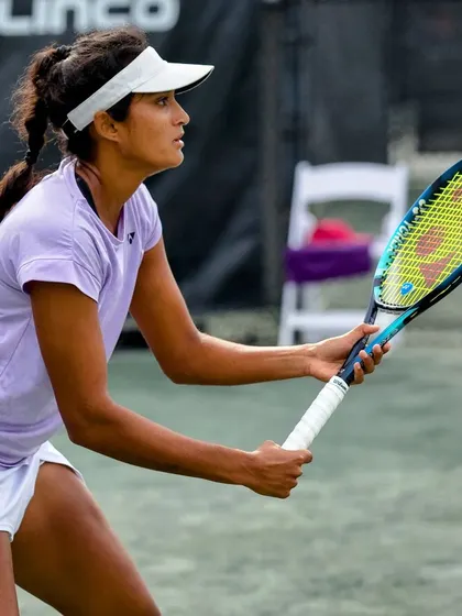 Sahaja readies for a backhand return, her eyes locked on the ball, showcasing the concentration required in professional tennis.