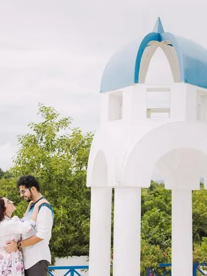 A classic couple pose against a Greek-style gazebo. The clean lines and natural background create a fresh and romantic pre-wedding photo.