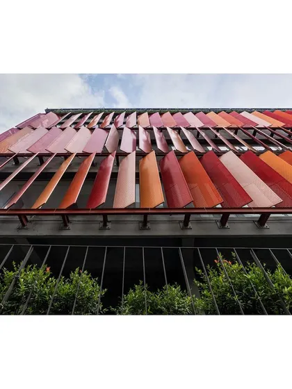 An upward-looking shot of the movable facade panels. This angle highlights the mechanical detail and the rhythmic pattern they create across the building's exterior.