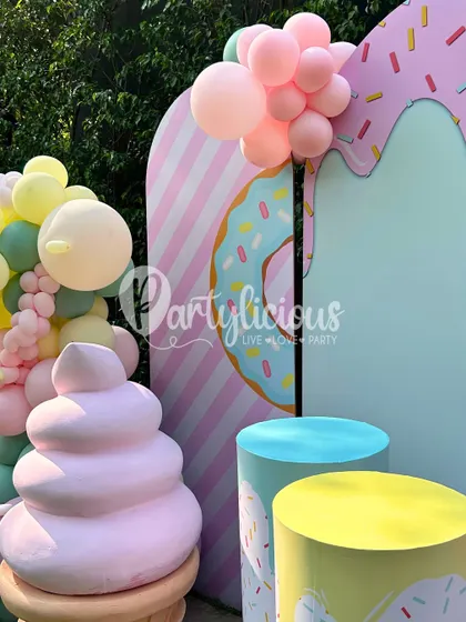 A close-up of the pastel-perfect ice cream and donut themed backdrop, showing the fun textures and shapes that make the setup so inviting.