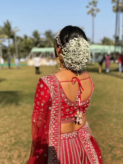 A classic bridal floral bun. I used a full arrangement of baby's breath to create this timeless and romantic look for a bride in a traditional red lehenga.