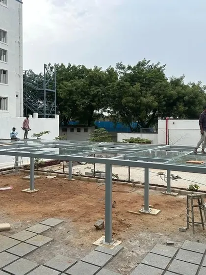 The framework for a glass-roofed pergola being installed at the Good Shepherd Cathedral. This structure is designed to provide a sheltered gathering space that still feels connected to the outdoors.