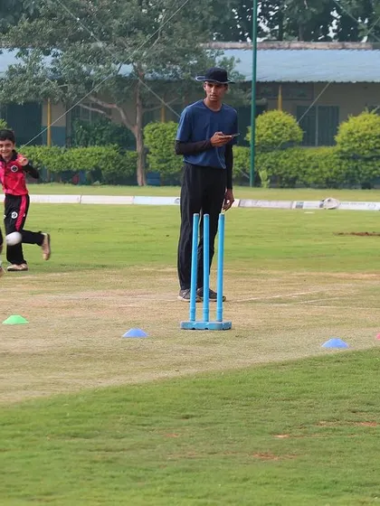 Young players practice running between the wickets during a training session.
