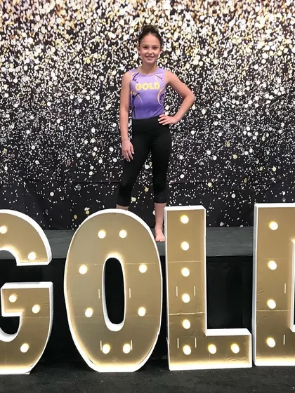 This Xcel Gold athlete stands proudly after competing at regionals in Colorado.