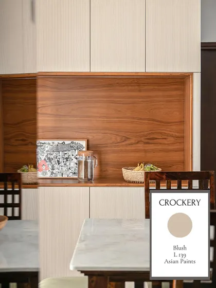 The crockery unit in the bedroom uses 'Blush', a soft neutral paint color that complements the warm wood tones and keeps the storage unit from feeling heavy.