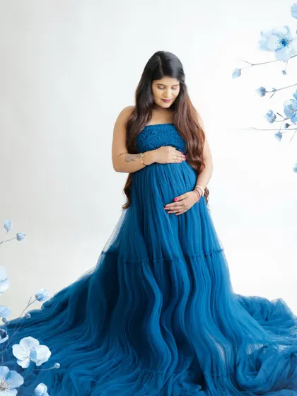 A duplicate of image 24, this creative portrait features a mom-to-be on a floral moon, looking regal in a deep blue tulle gown.