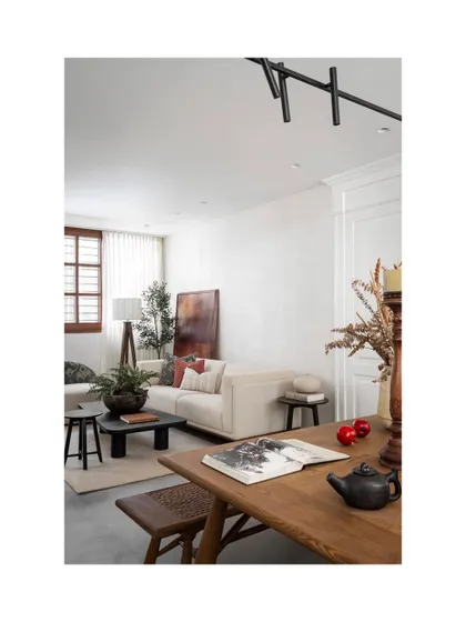 A composition in warmth and weight, this space balances the sculptural with the soft. The linen-toned sofa rests low and grounded, layered with cushions that nod to both texture and memory.