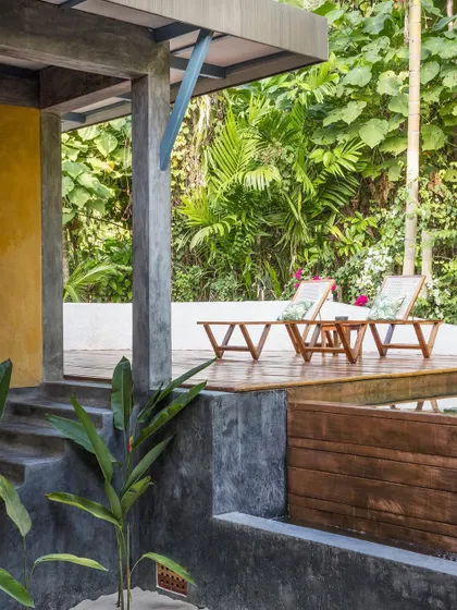 The deck of the private villa at Jalakara, with lounge chairs overlooking the dense tropical forest.