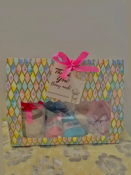 A close-up of the teddy bear themed baby shower hamper, featuring a candle, soaps, and a "Thank You Beary Much" tag.