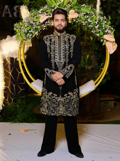 This black kurta, adorned with intricate gold embroidery, is perfect for a glamorous event. The detailed work on the chest and hem makes it a truly special occasion wear.