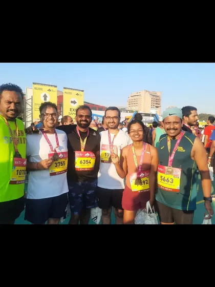 A runner proudly displaying his medal after the TCS World 10k. He beat his previous time by almost 4 minutes.