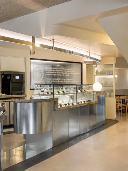 The patisserie and billing counter, crafted from the same industrial materials as the brew bar to create a cohesive design language.
