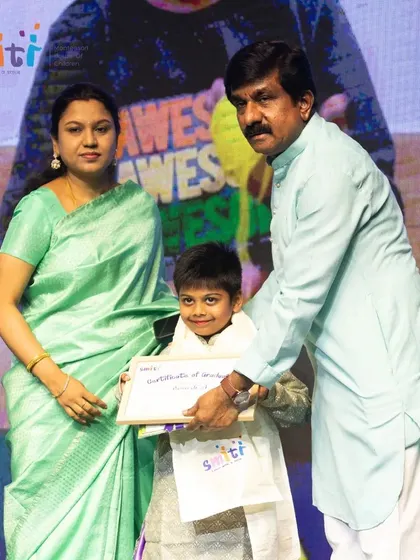 A graduate smiles as he receives his certificate, a proud moment capping his time at Smiti.