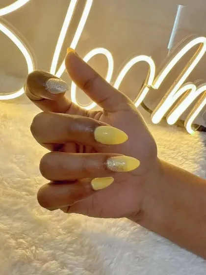 A fun shot of the yellow sunshine nails against our studio's neon sign.