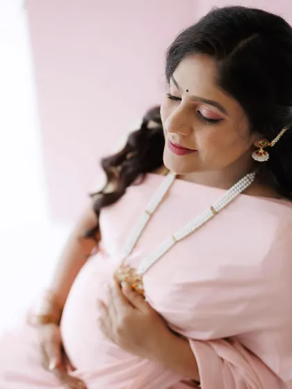 Another angle from the pink saree maternity shoot, showing how the soft makeup and hairstyle come together. The look is gentle and feminine, perfect for celebrating this special time.