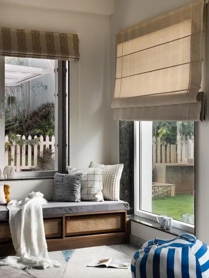 I transformed this corner into a cozy reading nook with a custom-built storage bench. The natural light, comfortable cushions, and cane-fronted cabinets make it the perfect spot to relax with a book, while also providing practical, hidden storage.