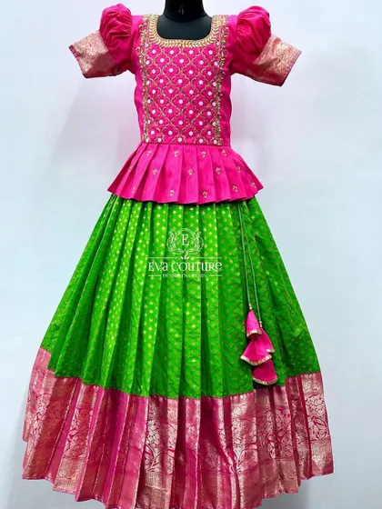 A bright and festive lehenga in parrot green and hot pink. The pink peplum blouse has a beautiful embroidered pattern, and the green skirt has a matching pink border.