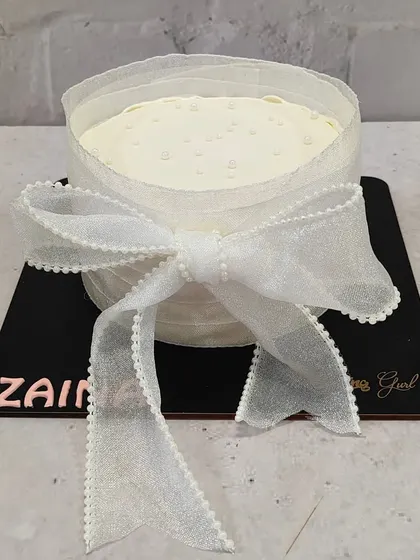 A gift-wrapped cake! This design uses a delicate, edible fabric bow to create a beautiful and unique presentation for a special celebration.