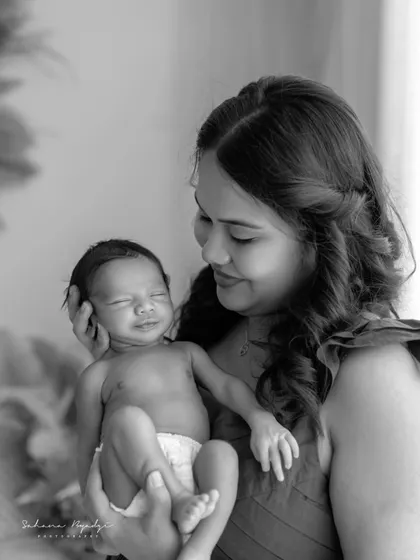 A beautiful black and white portrait of a mother holding her smiling newborn. The baby's joyful expression is a precious, fleeting moment that I was so happy to capture.