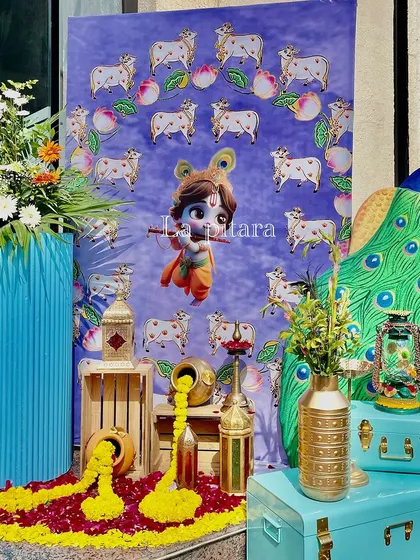 Another creative photo corner with a cute illustration of baby Krishna. The setup was brought to life with a large peacock cutout, colorful trunks, and marigold flowers spilling from a pot.