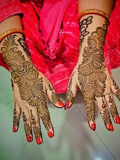 A clear, top-down view of an elegant Arabic-style mehandi trail on the back of the hands.
