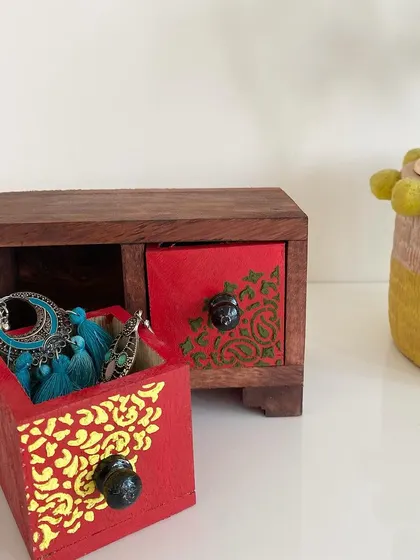 A different angle of the two-drawer jewelry box, showing one drawer open. The solid wood construction and detailed painting make it a durable and beautiful piece for your dresser.