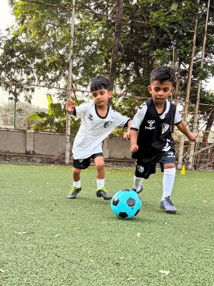 Two players challenge for the ball, showing the determination and competitive edge we nurture in our young athletes.