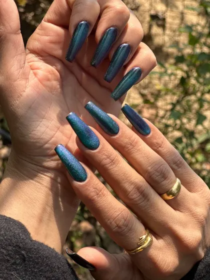 This peacock nail set is pure magic. Using a special cat-eye polish, the colors shift from deep blue to vibrant green depending on the light. It's a long-lasting gel extension look that guarantees compliments.