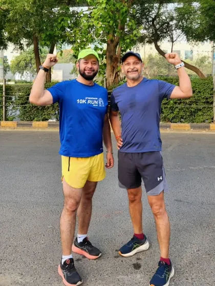 Two of our male runners, arms raised in a victory pose after a successful training run.