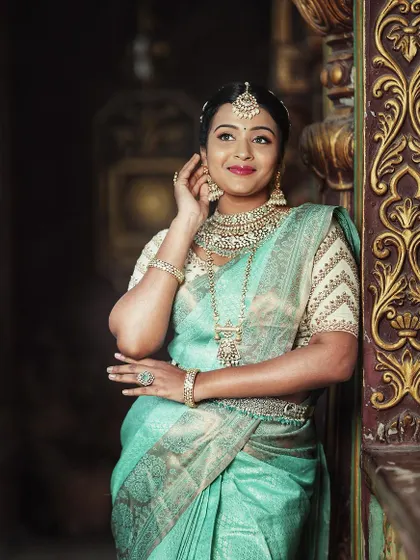 A picture of grace in our mint green silk saree, paired with a cream-colored embroidered blouse.