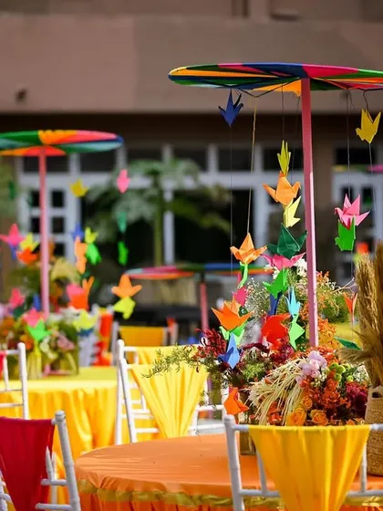 Whimsical table centerpieces with colourful pinwheels and paper cranes, adding a playful touch to the guest seating.