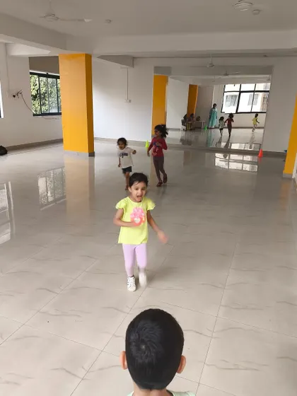 A young girl runs with excitement across the polished floor of our indoor facility. The open space allows for plenty of movement and energetic games, even when indoors.