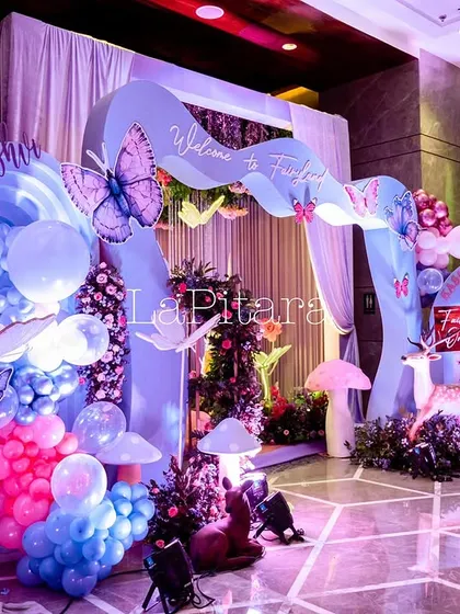 An entrance display with whimsical props like deer and mushrooms, welcoming guests to the fairyland.