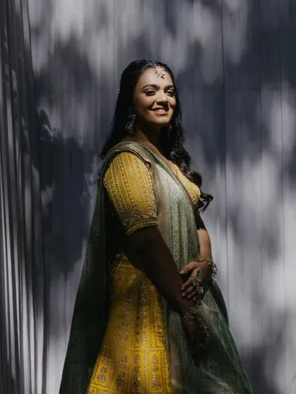 The sunlight creates a beautiful shadow play, highlighting her radiant smile and glowing skin.