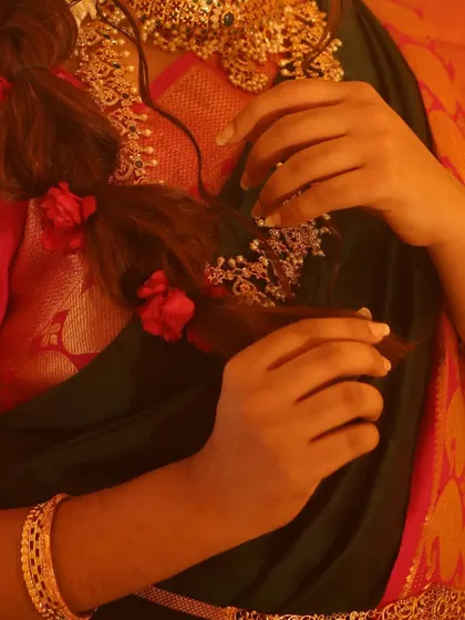 A close-up of a more modern take on a bridal braid. This style is looser and adorned with delicate flowers, offering a softer, more romantic feel for an engagement or sangeet.