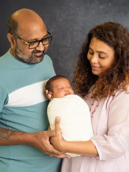 A beautiful portrait of new parents admiring their sleeping baby. This image perfectly captures the overwhelming love and wonder that fills the first few weeks of parenthood.