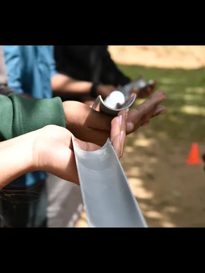 A close-up of a team building challenge that requires focus, communication, and steady hands. These activities are designed to highlight the importance of teamwork.