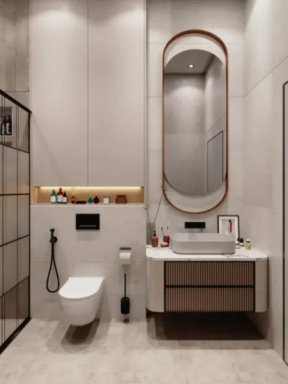This minimalist bathroom design features a floating vanity with a ribbed-texture drawer front. The clean lines are complemented by a simple, elegant oval mirror and a built-in storage niche with backlighting.