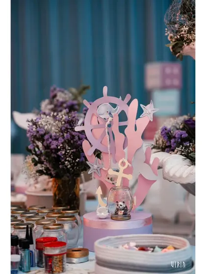 An activity table set up for the kids, featuring ocean-themed crafts and jars of supplies. I believe in providing creative and engaging activities to keep the little ones entertained.