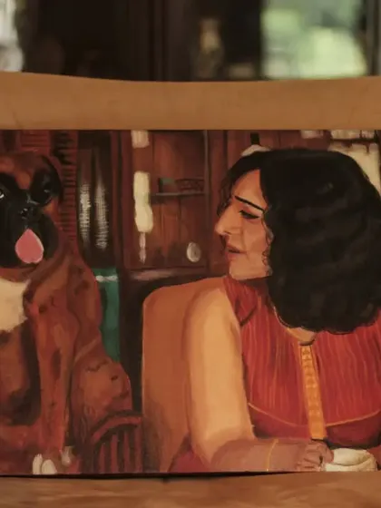 This commissioned acrylic painting of a woman and her boxer is set in a warm, cozy room, creating a feeling of home and companionship.