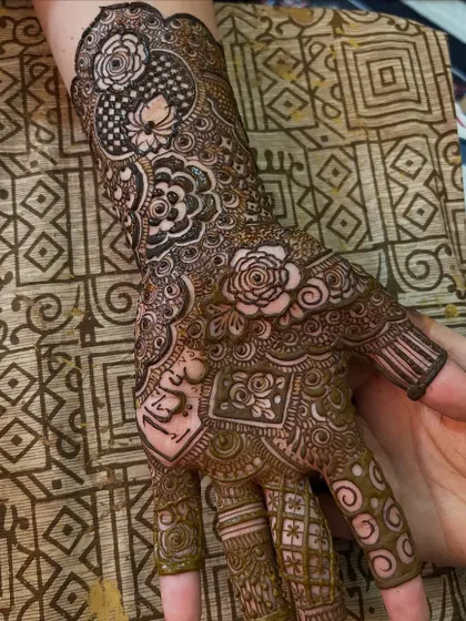 A close-up of the palm, showing the intricate details and the groom's name hidden within the design.
