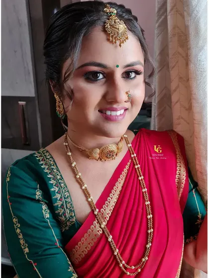 Varshini looking radiant by the window, with natural light highlighting her flawless engagement makeup.