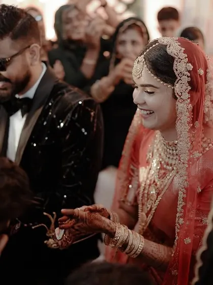 A moment of shared joy and celebration, with the bride and groom surrounded by the smiling faces of their family and friends.