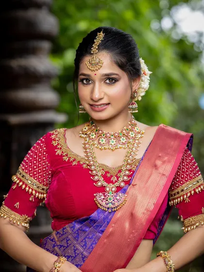 A close-up portrait that captures the bride's happiness and the beauty of the temple jewellery she is wearing.