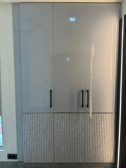 A four-door wardrobe with a modern design, combining high-gloss grey laminate on top with a textured, fluted panel at the bottom.